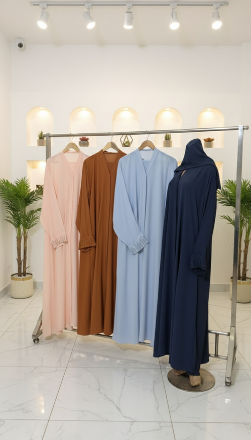 Four long-sleeve dresses in different colors hanging on a rack against a white wall.